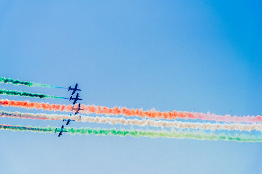 Frecce Tricolori flying across a blue sky with Italian tricolor smoke trails