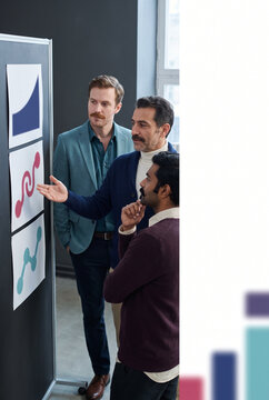 Business professionals analyzing graphs during a presentation meeting  