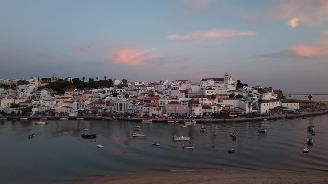 Scenic ferragudo fishing village harbor at sunset