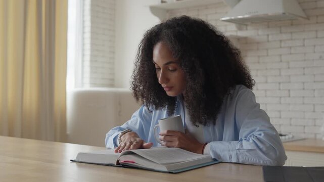 Woman Reading Book At Table With Focused And Calm Expression