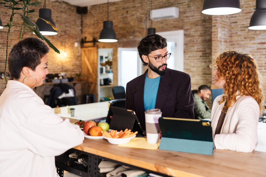 Colleagues chatting during breaktime in modern office