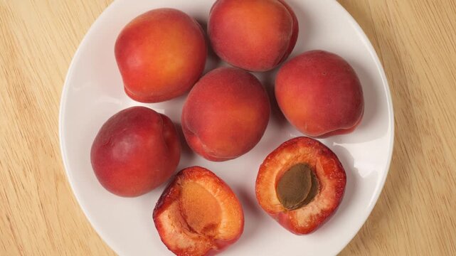 Ripe fresh apricots rotating on a plate