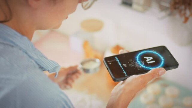 Artificial intelligence technology simplifies home baking as a housewife prepares cottage cheese pancakes following voice assistant instructions. Concept of a smart home and modern kitchen technology