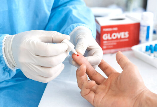 Medical professional administering finger prick blood test procedure