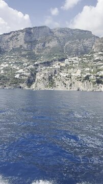 Dramatic Rocky Coastal Cliffs with Hillside Houses Above Blue Sea in 4K