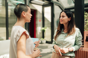 Professional women communicating and collaborating during a business meeting in a modern office...