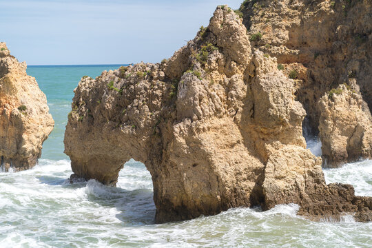 Arch rock formation in the ocean near Lagos Portugal with waves crashing