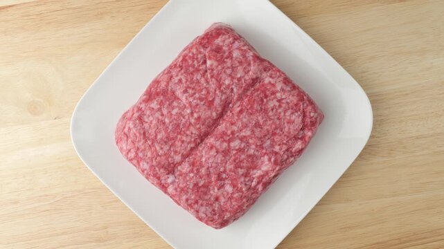 Fresh raw ground pork rotating on a plate