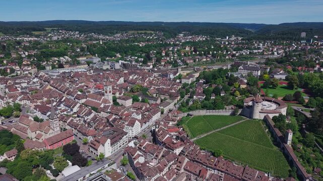 Aerial tracking view over the historic old town of Schaffhausen, featuring the Munot fortress, vineyard, church tower, and medieval cityscape.