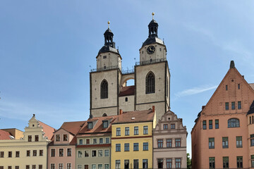 Obraz premium The twin towers of a church and the historic buildings in the old town of Wittenberg, Germany