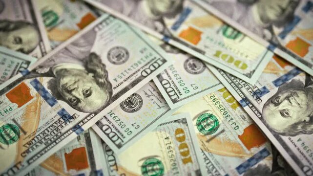 Ultra-close view of fresh one-hundred-dollar bills forms seamless texture backdrop, captured with smooth camera motion under even daylight, highlighting crisp currency, cash details, allure of money