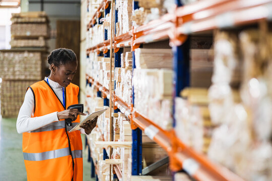 Female worker scanning inventory in lumberyard warehouse