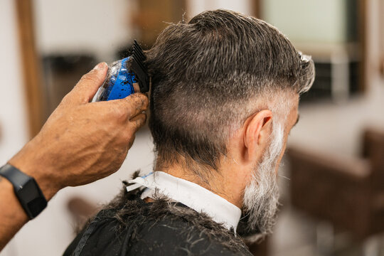 Barber cutting man's hair in salon