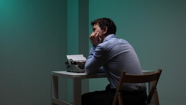 Thoughtful man sitting at a desk, looking away from a vintage typewriter, contemplating new ideas and experiencing a creative block in a moment of reflection and deep thinking