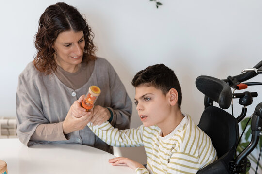 Mother doing sensory activities with child having cerebral palsy