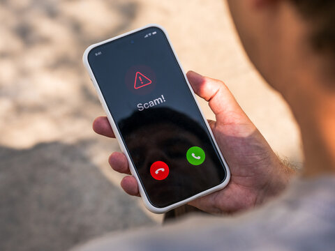 Scam call warning on smartphone alerts user to phone fraud, vishing, caller spoofing and identity theft risk, mobile cybersecurity and consumer protection.