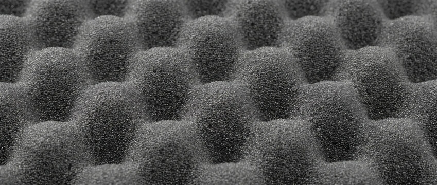 Egg crate acoustic foam texture in close-up. Dark soundproofing studio foam panel pattern
