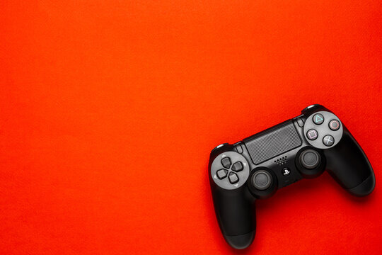 September 14, 2026, Odessa, Ukraine. Black Sony PS4 DualShock controller on bright red back