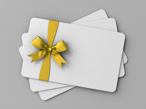 Blank white business gift cards or voucher mock up with gold ribbon bow isolated on grey background with shadow and copy space minimal concept 3D rendering