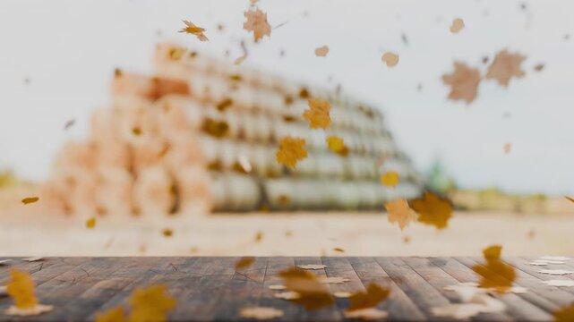 An autumn composition featuring autumn leaves falling onto a wooden surface; a rustic style that creates a sense of warmth. An empty wooden table with autumn leaves. The camera zooms in.