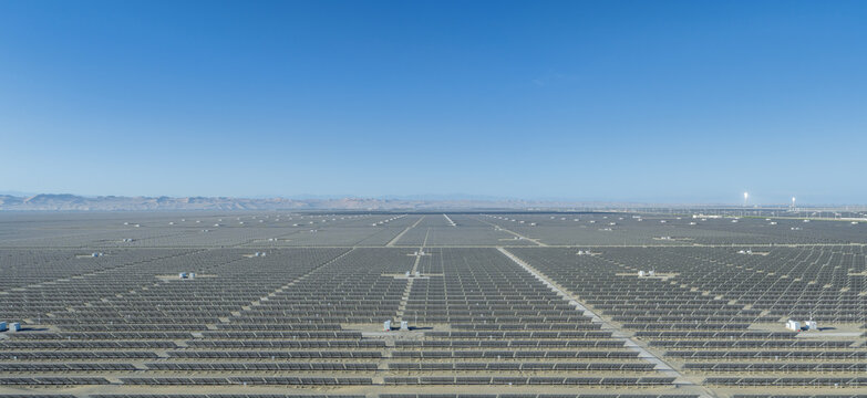 Aerial Morning View of Vast Solar Photovoltaic Power Station in Dunhuang Gobi Desert with Glowing Molten Salt Solar Thermal Tower