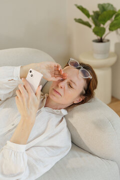 Eye Fatigue Troubles Middle-Aged Woman Reading Smartphone at Home
