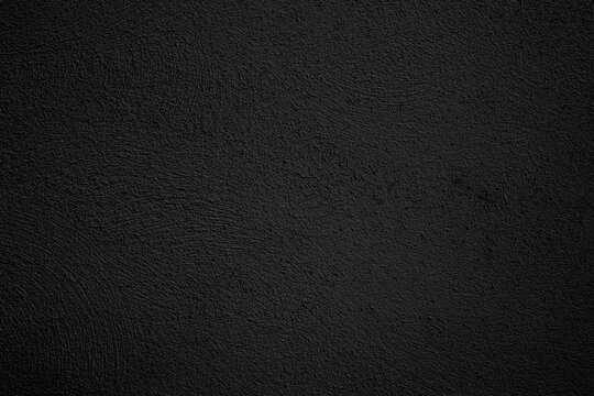  Fondo de estuco de pared texturizado de color negro oscuro. Superficie punteada rugosa, oscura y s&oacute;lida; transmite minimalismo industrial, sobriedad e interiores modernos.