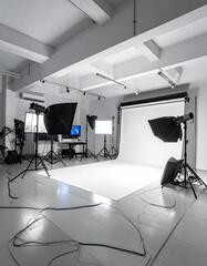 Fototapeta na wymiar Professional photo studio with white backdrop and lighting equipment, no people.