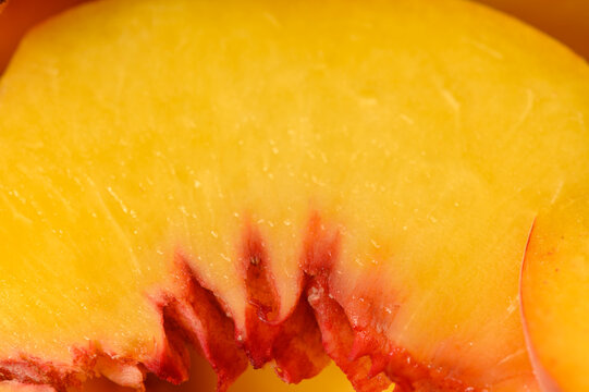 Commercial stock photo of an extreme macro detail of yellow peach flesh and red core structure