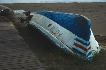 Weathered Fishing Boat Resting on Dark Sand Beach © Andrs