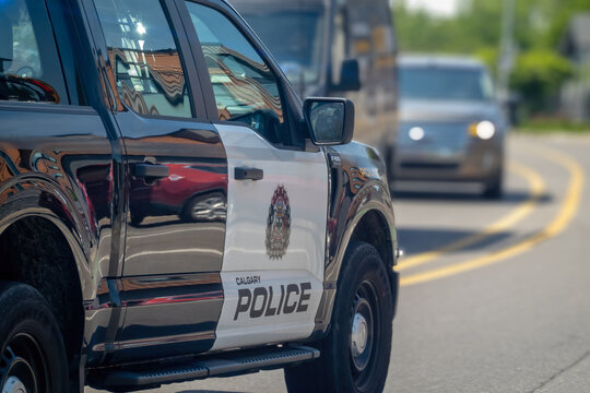 Calgary, AB, Canada - Sept 14, 2026: Side view close-up of a Calgary Police truck parked on a city street with traffic behind.
