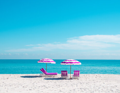 pink beach umbrella and lounge chair in miami florida