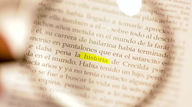 Slow-motion 4K macro close-up of a magnifying glass focusing on the highlighted word 'historia' under cinematic chiaroscuro light.