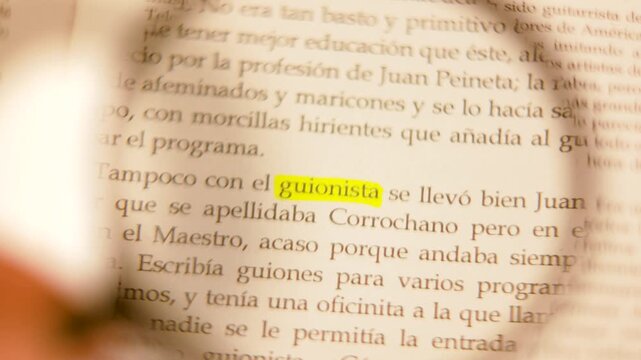 Macro shot of a magnifying glass focusing on the highlighted word 'guionista' on a Spanish book page.