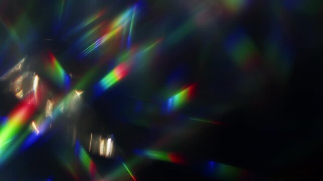 Light ray shining through a prism for beams of sparkling lights, shimmering bokeh, and a brilliant dazzling rainbow of lens flares. Visual effect of a light burst through swirling reflective glass.