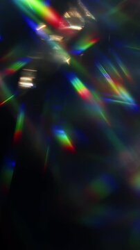 Light ray shining through a prism for beams of sparkling lights, shimmering bokeh, and a brilliant dazzling rainbow of lens flares. Visual effect of a light burst through swirling reflective glass.