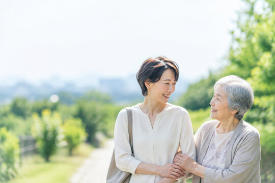 公園で腕を組み歩く日本人母娘の温かいシーン