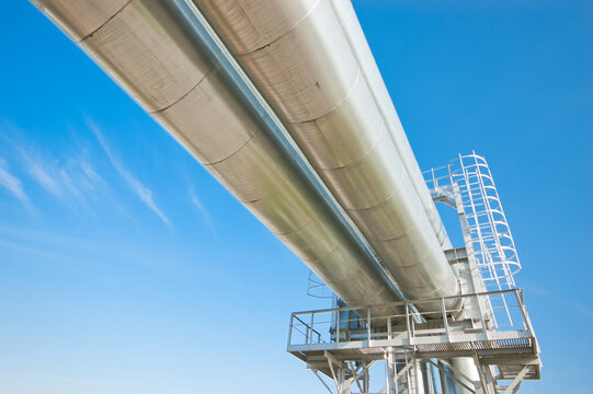 The photo shows a pipeline against a blue sky