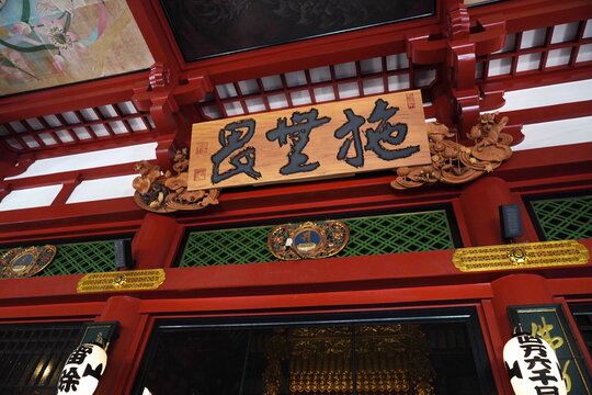 日本の伝統的な寺院の軒下にある扁額「施無畏堂」と赤い建築構造物、提灯が並ぶ厳かな宗教的空間。