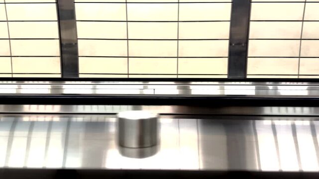 Dynamic motion footage of a modern moving walkway in an airport terminal, showcasing urban mobility, public transit, and fast-paced travel infrastructure.
