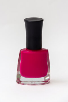 Bright magenta nail polish bottle with black cap isolated on a white background