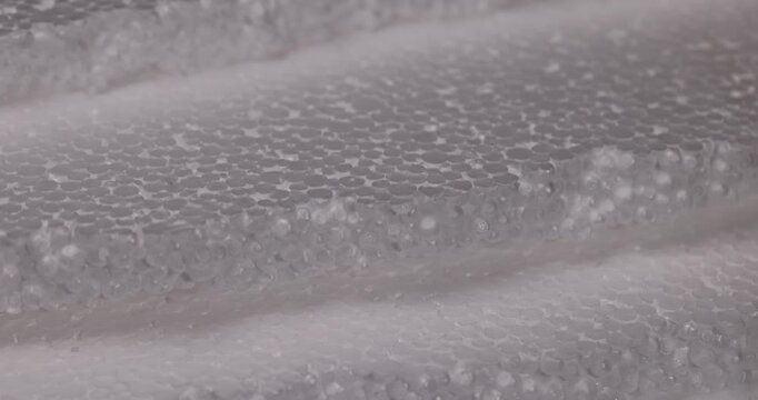 White foam with a wavy relief, this cellular foam is a series of projections of polymer foam balls for packaging.