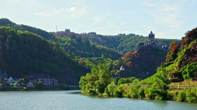 Cochem castle landscape view over the scenic Moselle river, featuring lush green hills, dense forests, and historic buildings in Rhineland-Palatinate, Germany