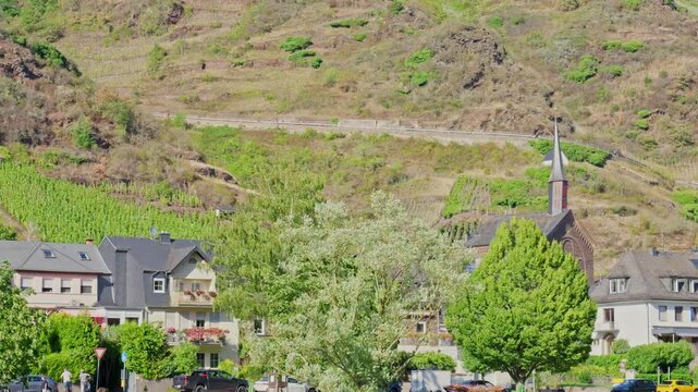 Scenic view of European village with church steeple and green hills on a sunny summer day