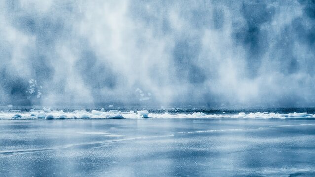 Mist rises from a frozen arctic landscape with drifting ice chunks. Cold weather background for climate change and winter nature concepts.