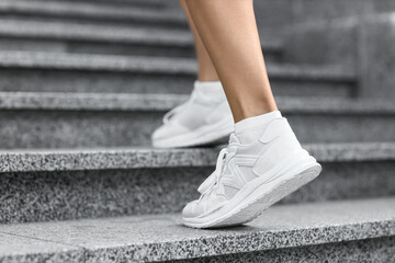 Obraz premium Sporty young woman jogging on stairs in park, closeup