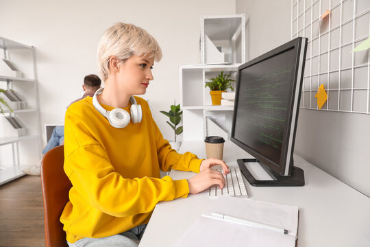 Female programmer working with computer at table in office