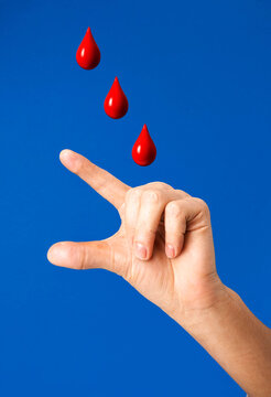 Hand gesture showing three falling red blood drop icons against blue sky