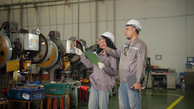 Factory engineers discussing steel production and metalworking process near heavy machinery, teamwork meeting manufacturing inspection and quality control, industrial safety and machine shop operation
