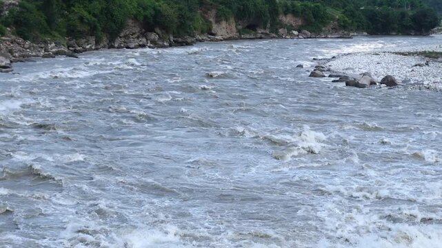 Raging river water flowing fast through a forest landscape